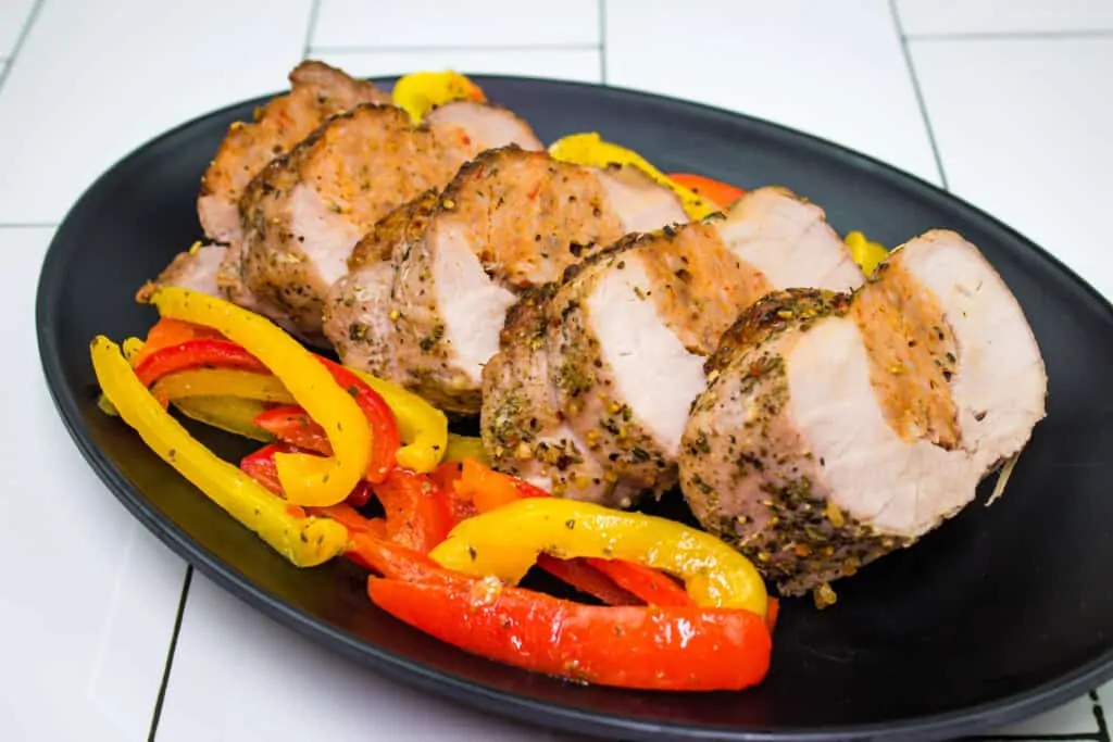 sausage stuffed pork tenderloin with peppers on a plate