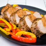 sausage stuffed pork tenderloin with peppers on a plate