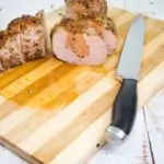 sliced sausage stuffed pork tenderloin on a cutting board