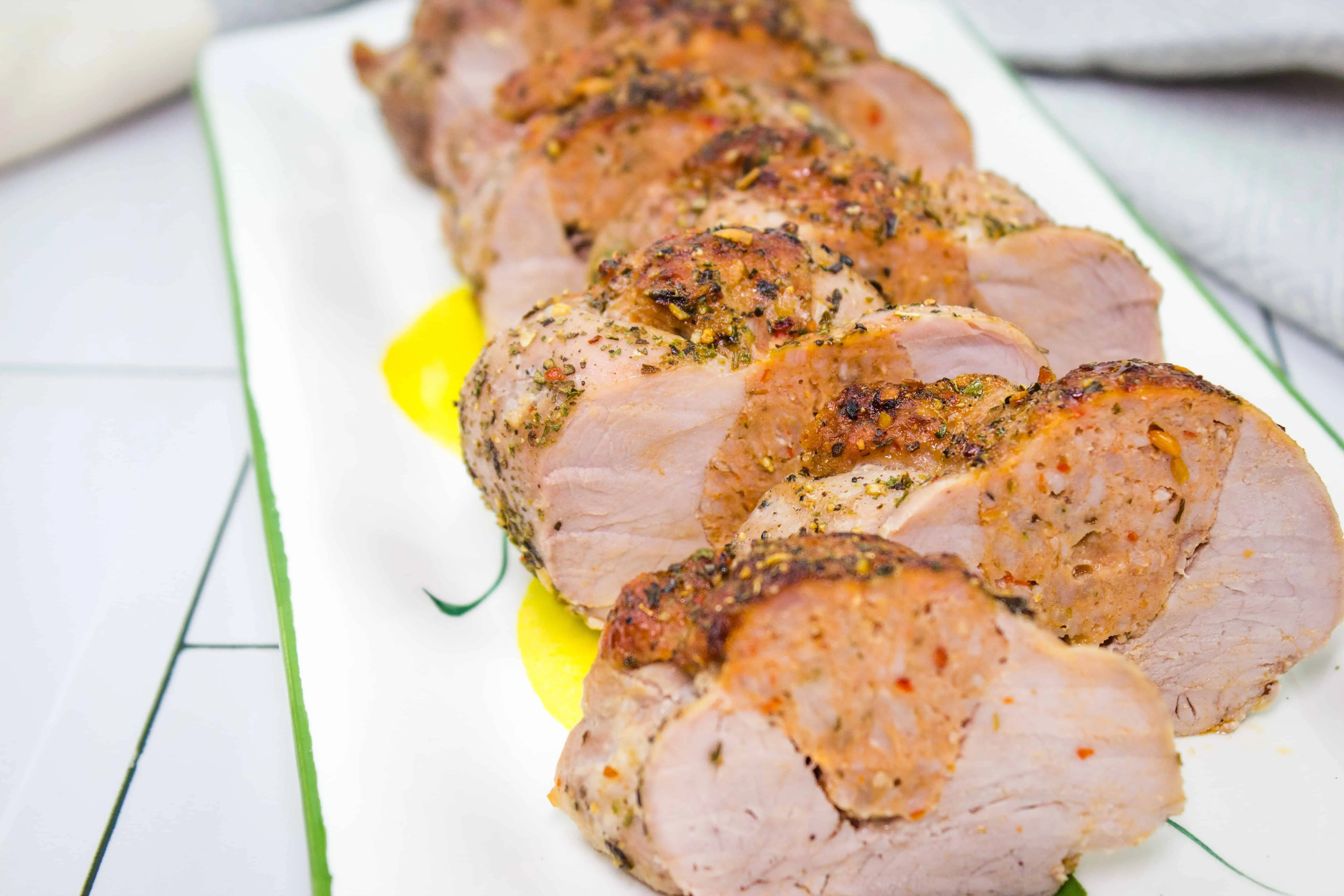 sausage stuffed pork tenderloin on a platter