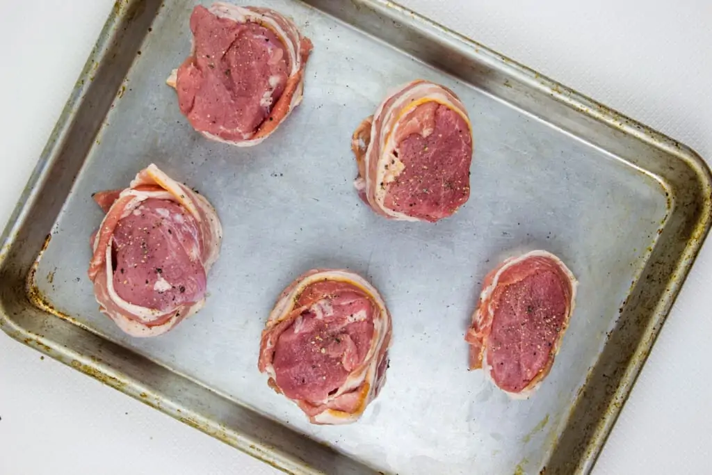 bacon wrapped pork tenderloin on a sheet pan