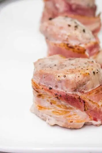 bacon wrapped pork tenderloin on a plate