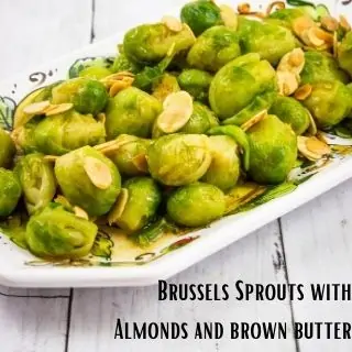 brussels sprouts with brown butter in a serving bowl on a wooden table