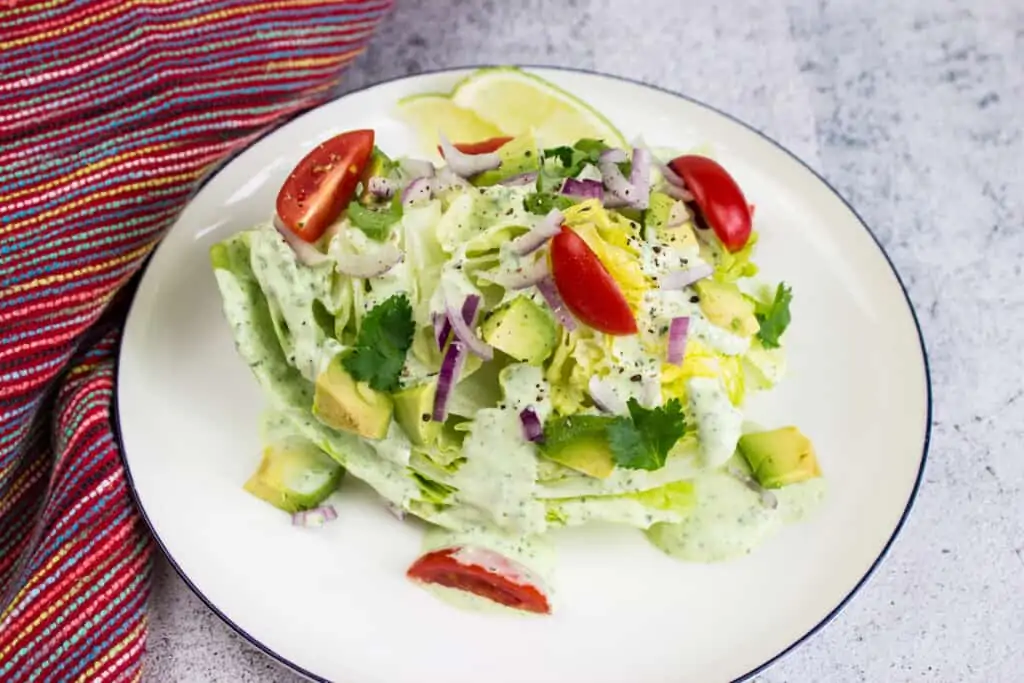 keto creamy jalapeno dip as a salad dressing on a wedge salad with tomatoes