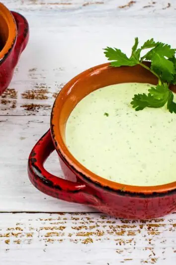 keto creamy jalapeno dip in a rustic bowl with a bowl of low carb chips in the background