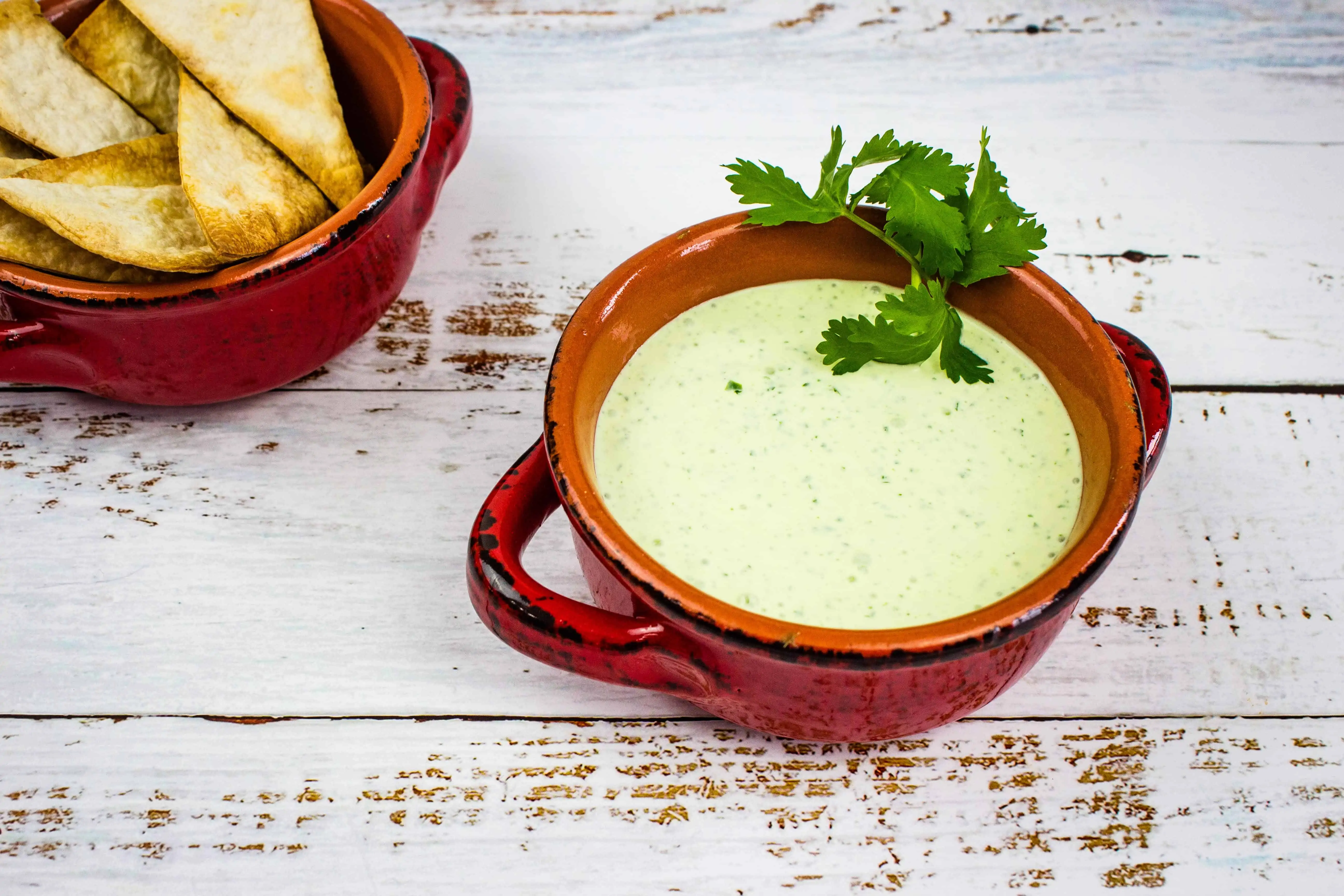 keto creamy jalapeno dip in a rustic bowl with a bowl of low carb chips in the background