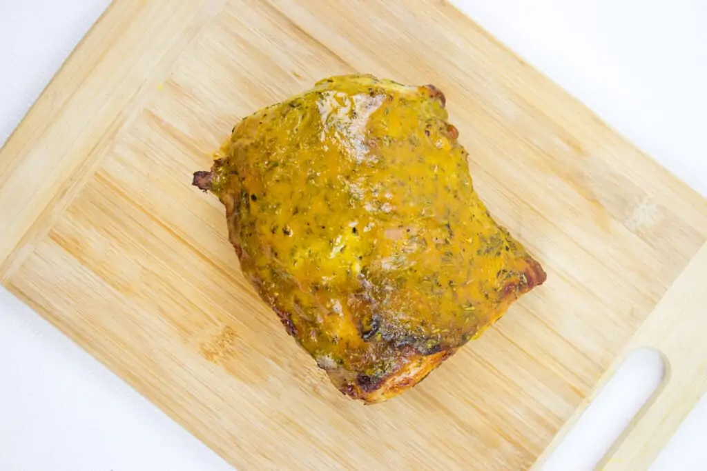 Brown sugar mustard glaze pork roast resting on a cutting board.