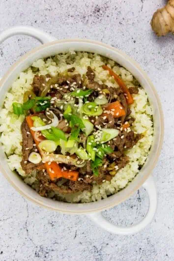korean beef bowl with garlic and ginger in the background