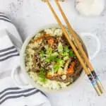 korean beef bowl with garlic and ginger in the background