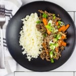 keto korean beef bowl on a black plate with cauliflower rice