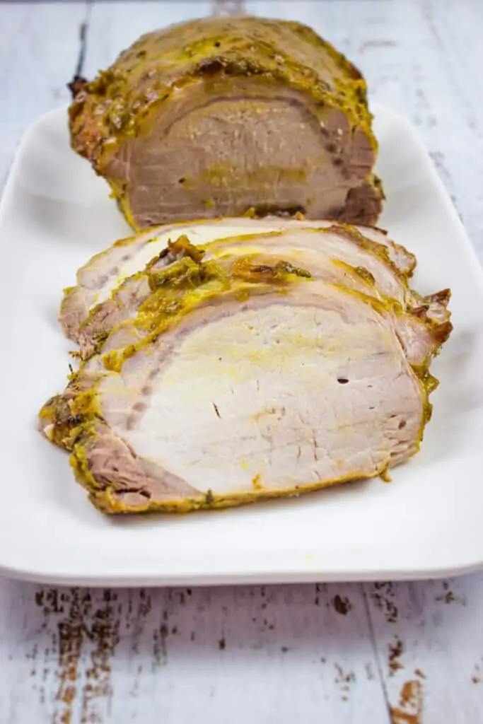 brown sugar mustard glaze pork roast sliced on a plate