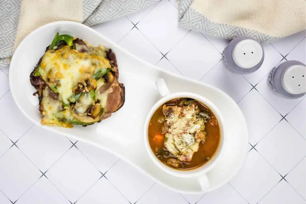 Keto Philly Cheesesteak Stacks on a plate with Beefy Minestrone Soup