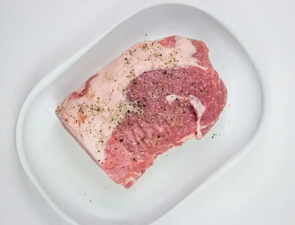 pork loin seasoned with salt and pepper on a plate