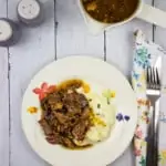 keto pot roast with bacon on a plate with mashed cauliflower
