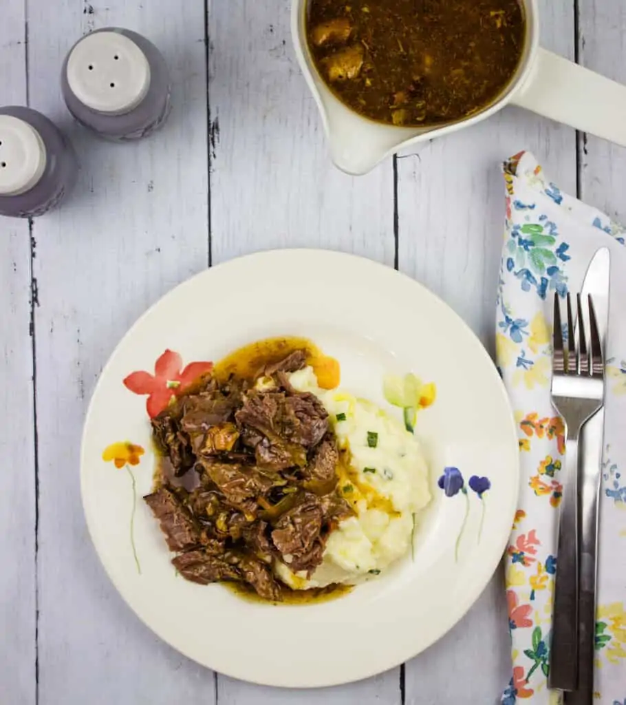 keto pot roast with bacon on a plate with mashed cauliflower