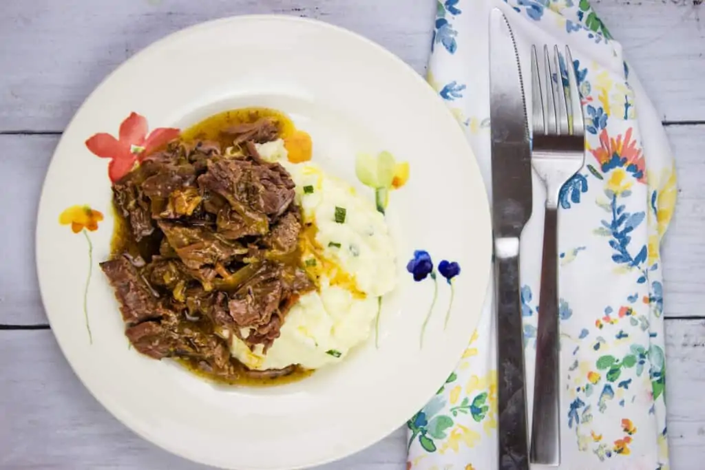 keto pot roast with bacon on a plate with mashed cauliflower