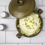 cheesy cauliflower mash in a casserole dish with the lid