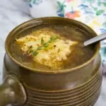 keto french onion soup topped with low-carb bread in an olive green soup bowl