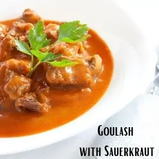 a serving of goulash with sauerkraut in a white bowl