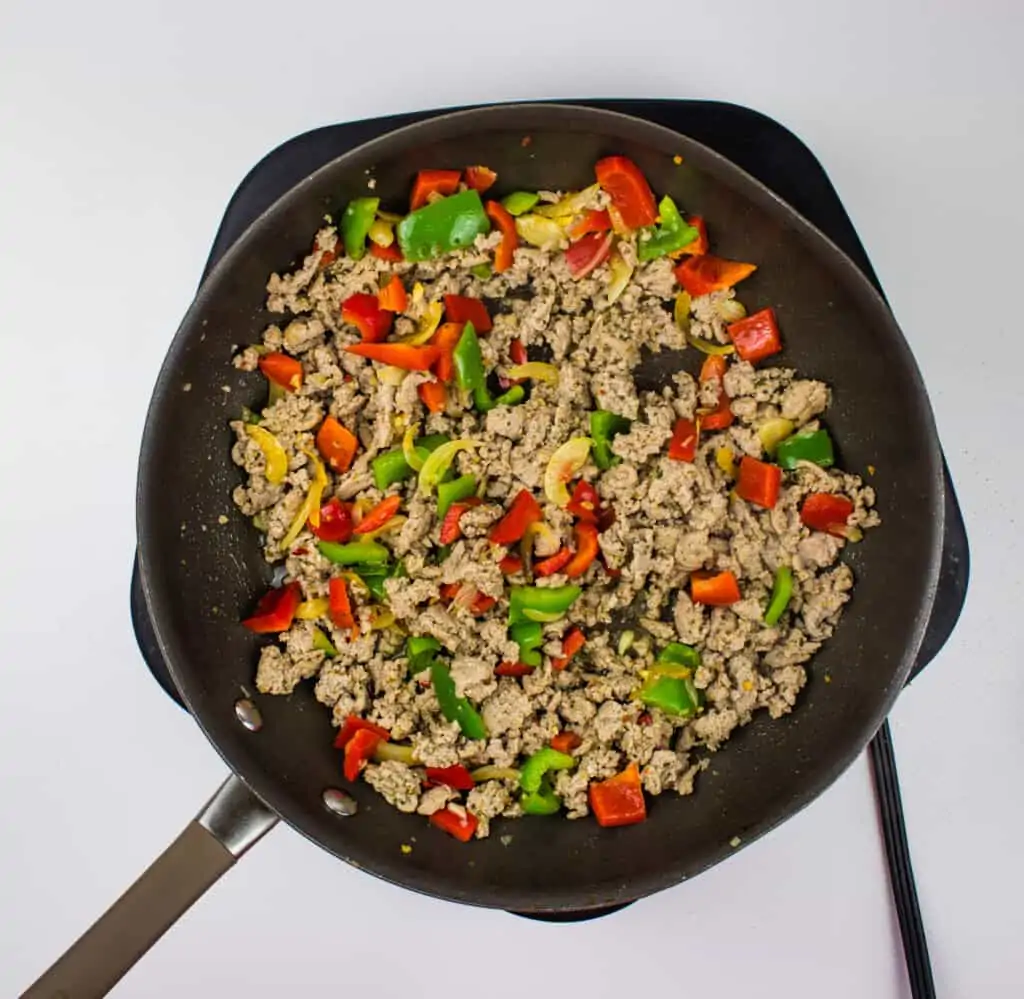 a skillet with ground turkey and red and green peppers in it. Enjoy your keto ground turkey and peppers meal!