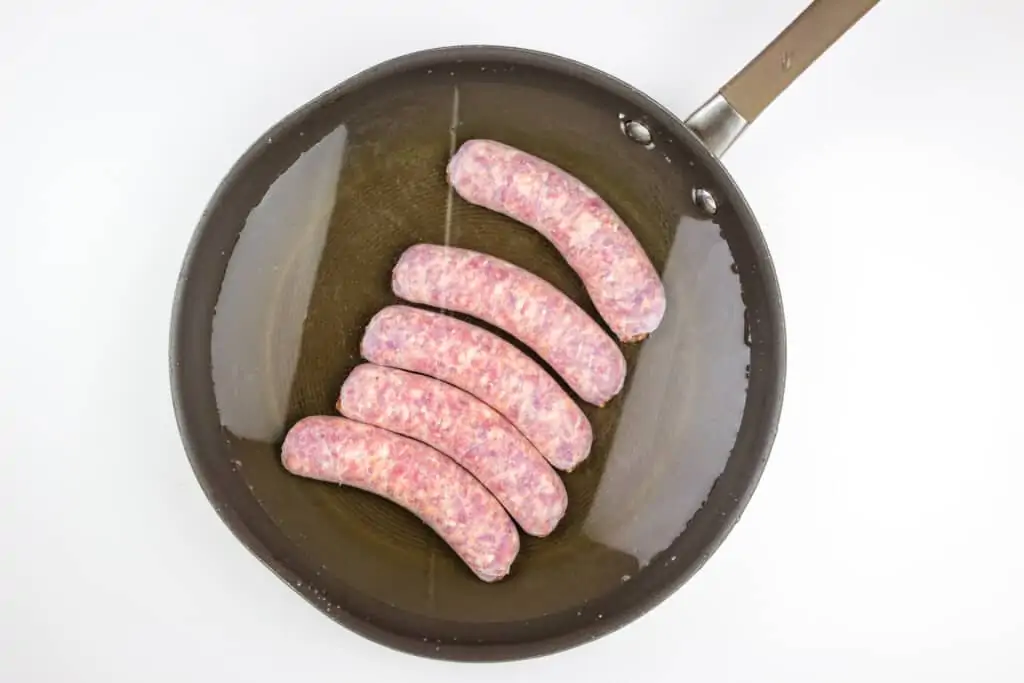 raw sausage in a skillet with water 
