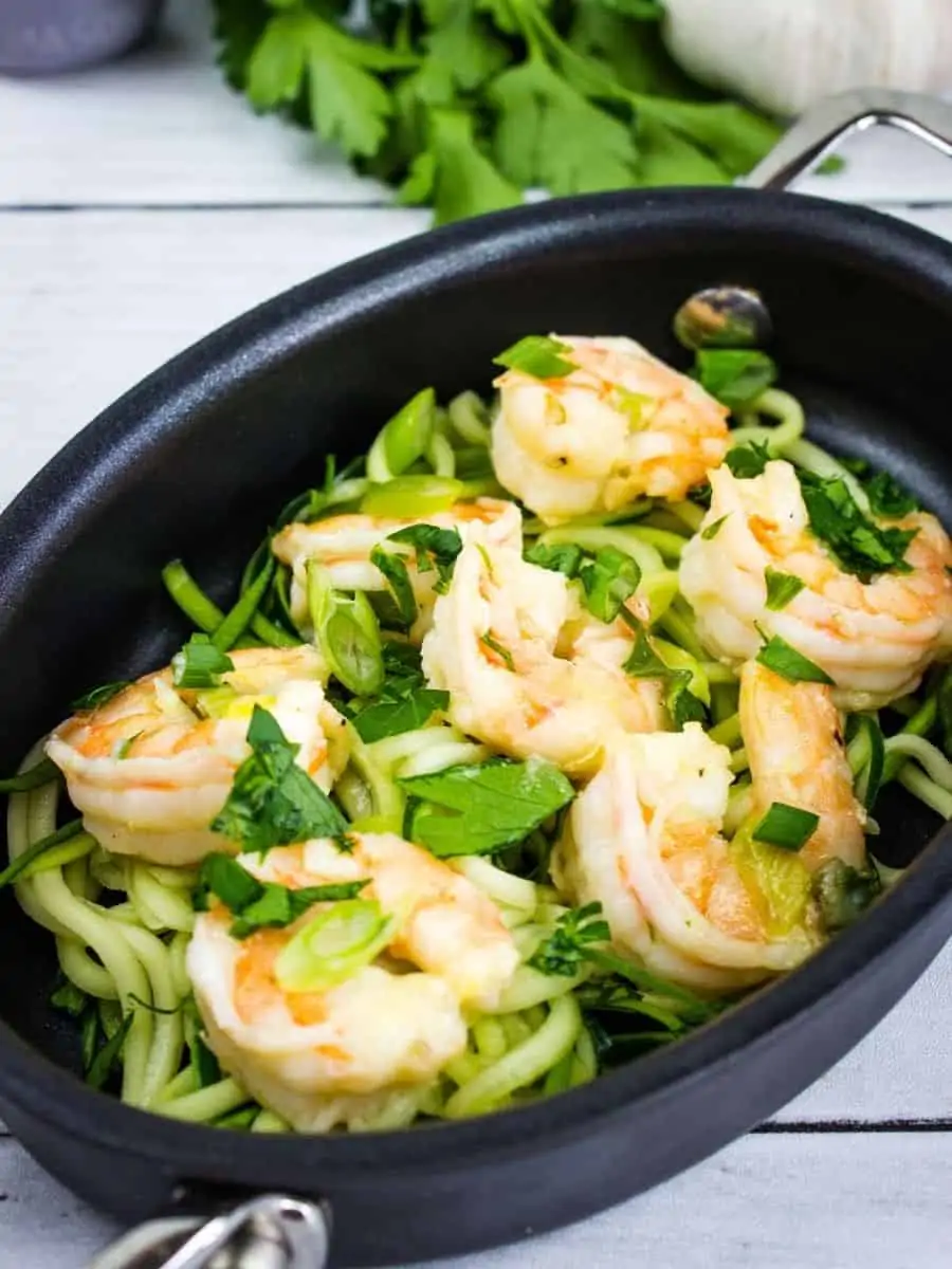 shrimp scampi in an oval serving dish with zucchini noodles