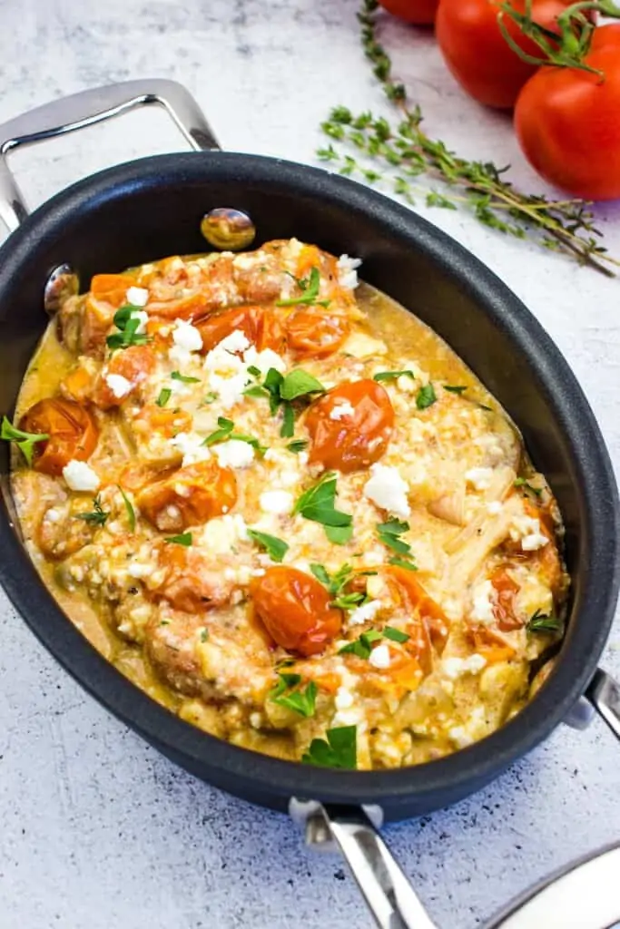 cheesy and creamy baked feta pasta in a black oval dish