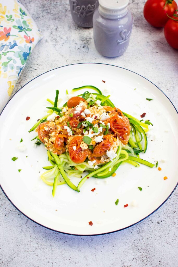 keto baked feta pasta with tomatoes on a bed of zucchini noodles