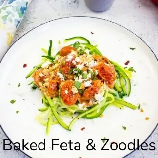 baked feta with tomatoes on a bed of zoodles