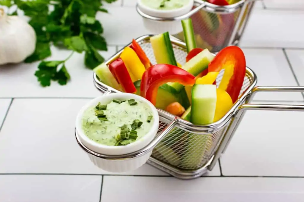 keto green goddess dressing in a ramekin with veggies for dipping