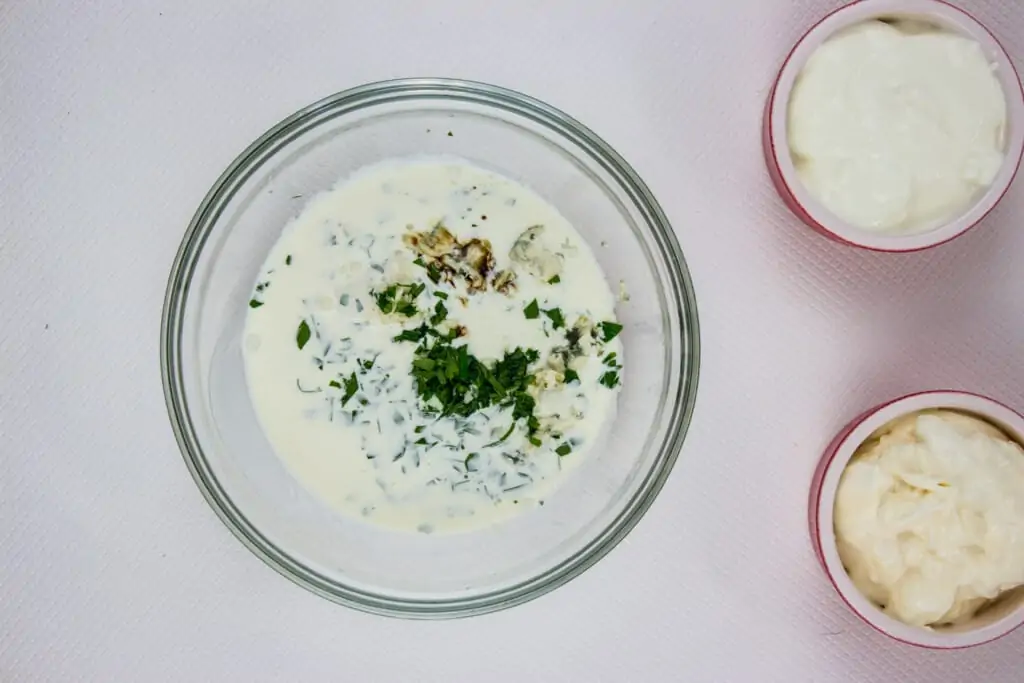 A bowl with the sour cream, mayo, lemon, Worcestershire sauce and parsley