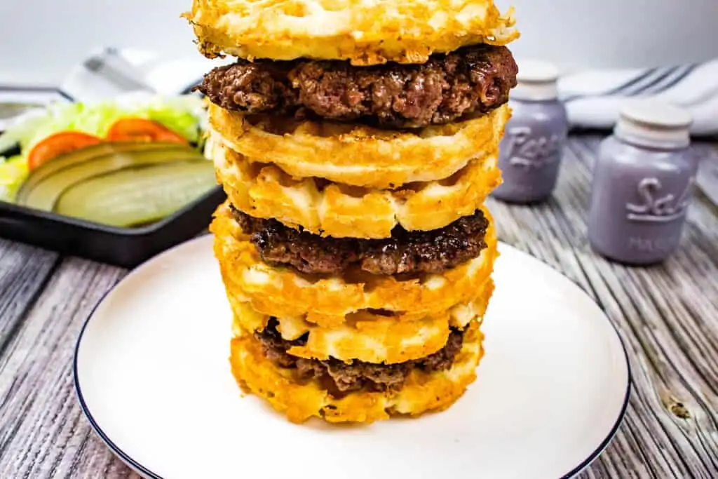 a stack of three keto butter burgers with condiments in the background