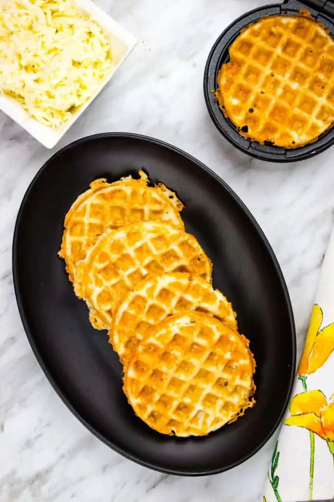 Crispy keto chaffle recipe served on a black serving plate with mozzarella in the background