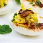 keto deviled eggs with bacon on a white platter