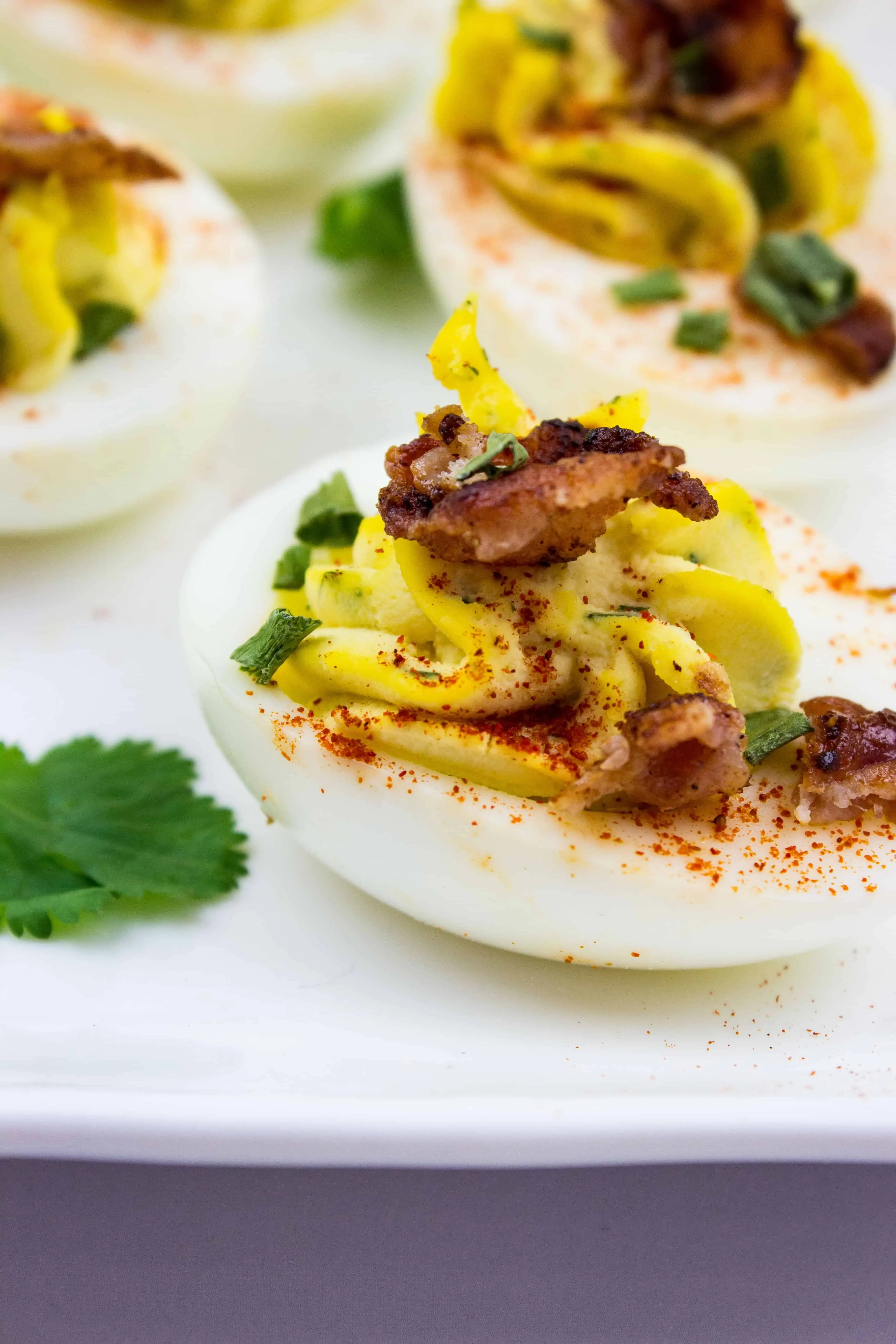 keto deviled eggs with bacon on a white platter