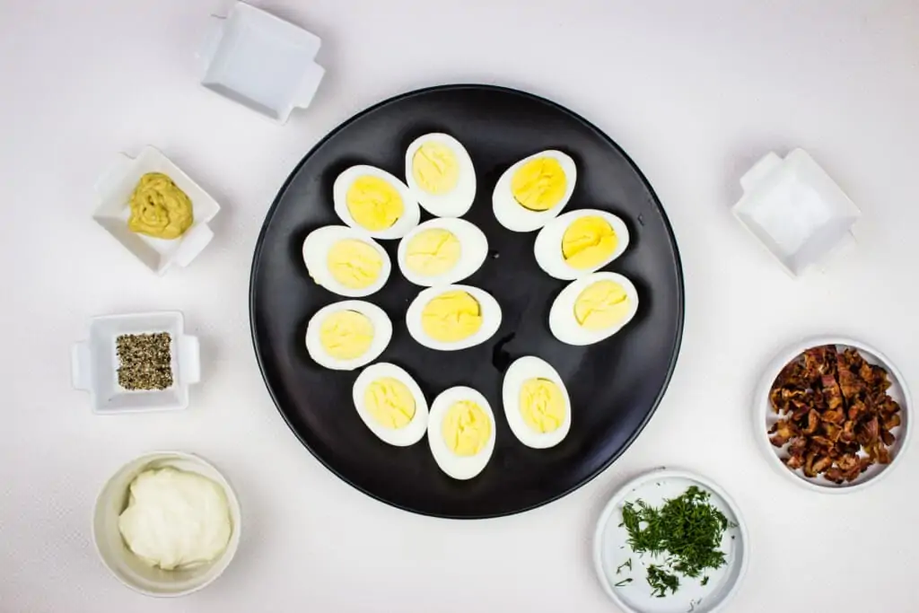 perfectly boiled eggs and prepped ingredients to make keto deviled eggs with bacon