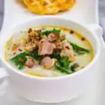 keto zuppa toscana soup in a bowl with a chaffle in the background