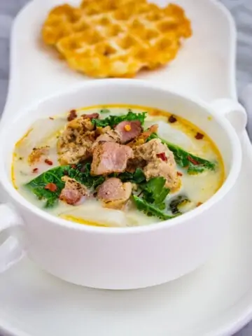 keto zuppa toscana soup in a bowl with a chaffle in the background
