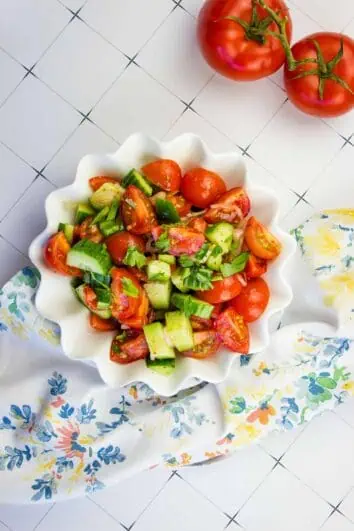 keto cucumber tomato salad in a white serving bowl
