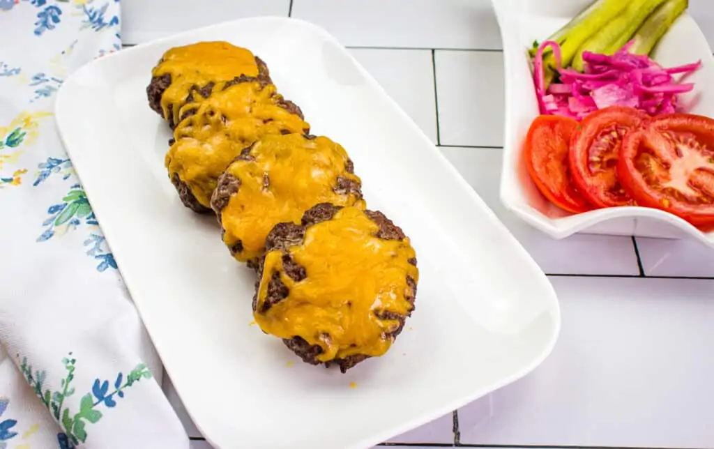 keto air fryer burgers on a platter with veggies in the background