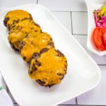 keto air fryer burgers on a platter with veggies in the background