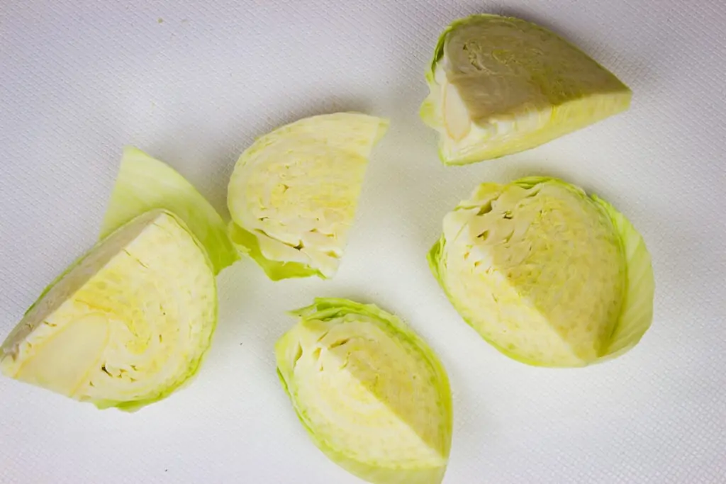 Green cabbage that's been cut into wedges.