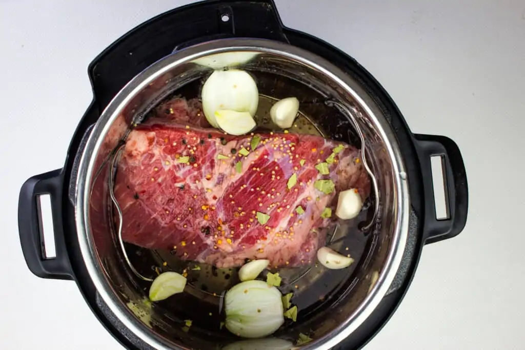 Add the corned beef, onion and garlic to the Instant Pot.