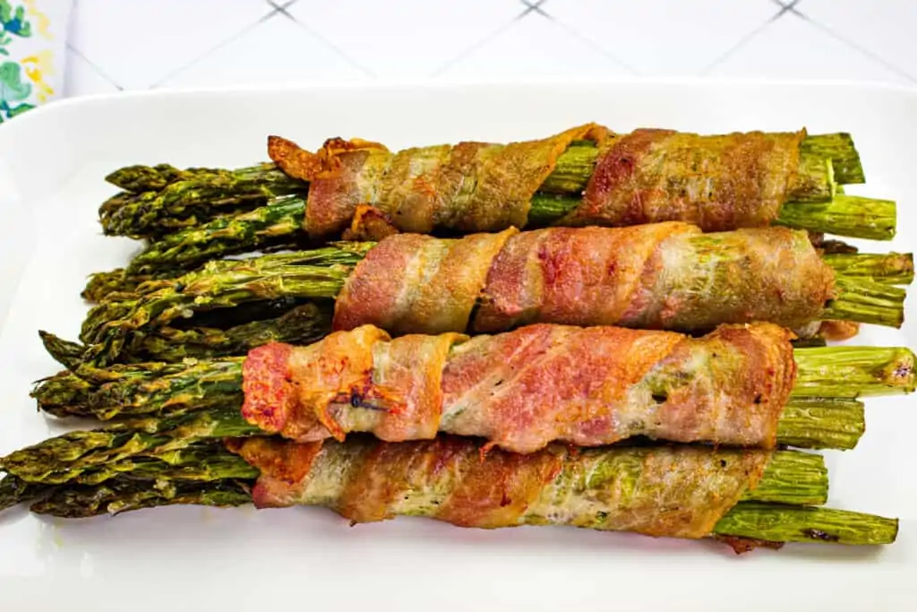 bacon wrapped asparagus air fryer on a white platter