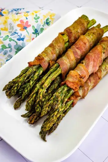 bacon wrapped asparagus on a white platter