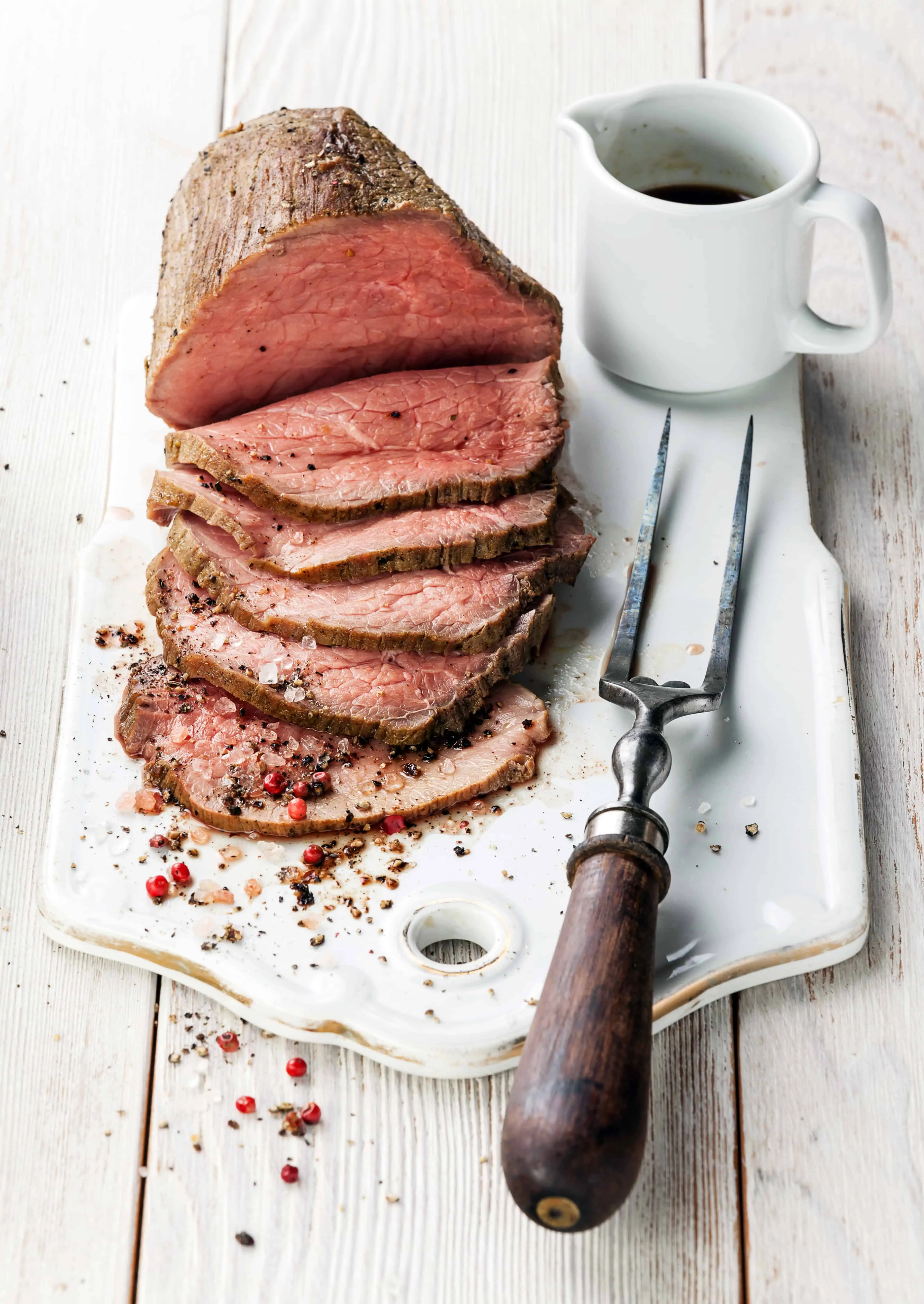 sliced roast beef on a board with a fork