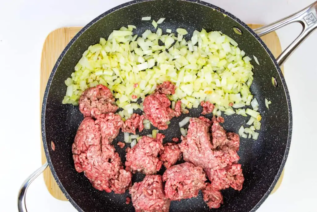 cooking the beef and onion in a skillet to make keto stuffed peppers