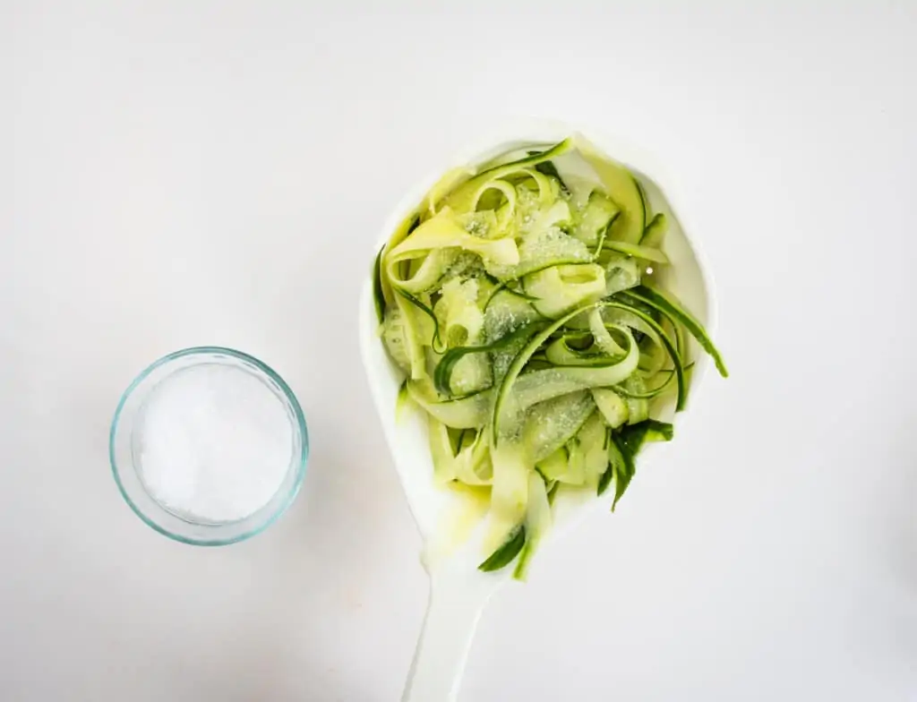 a strainer with thin slices of cucumber