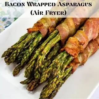 Bacon wrapped asparagus on a white plate.