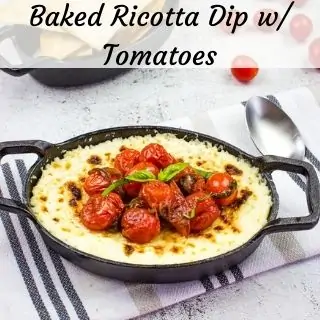 baked ricotta dip with tomatoes in a black serving dish